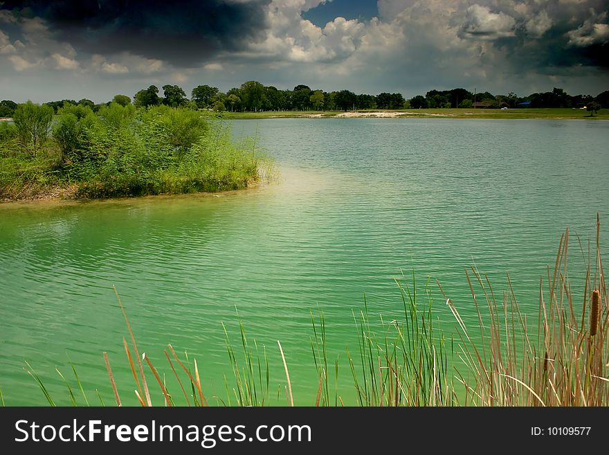 A small lake in a park near a picnic ground