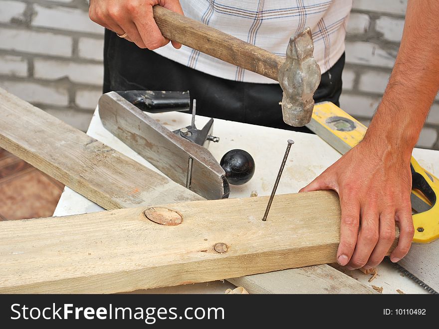 Hammer pounding nail close-up