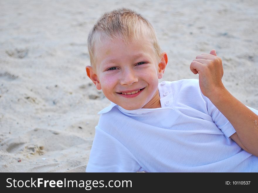 Happy boy on sand background