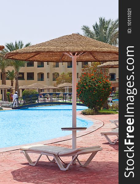 Umbrella and plank bed near pool