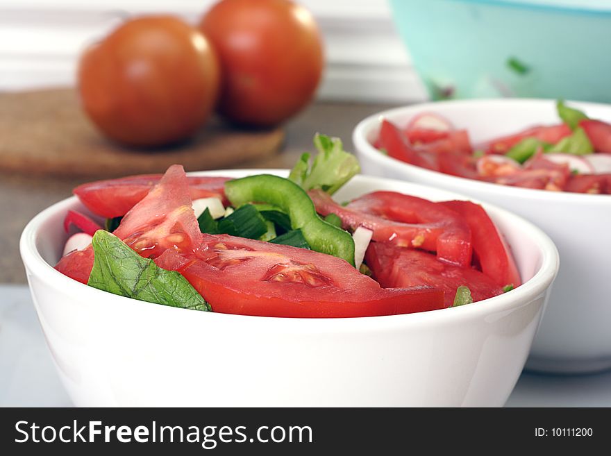 Two bowls of fresh cut tomato salad