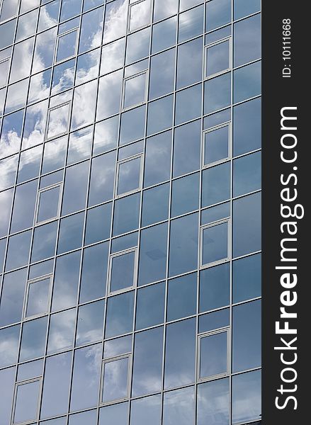 Mirror image of Clouds reflected on windows of building