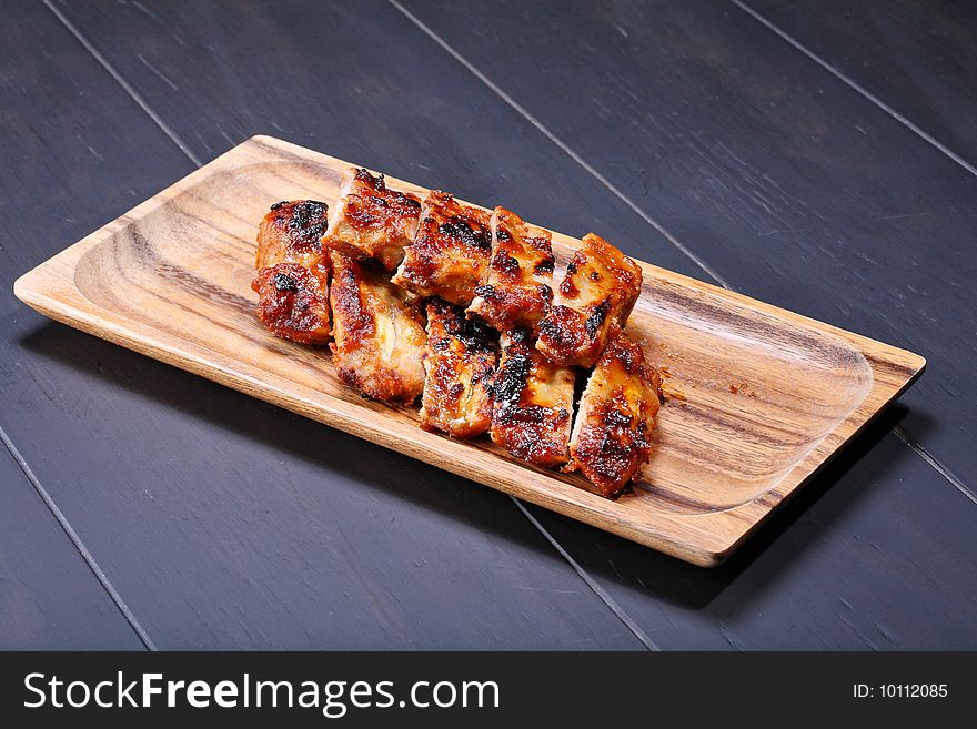 Grilled pork ribs on wooden plate