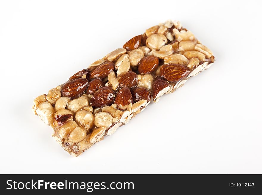 Cereal bar with nuts, almonds and honey on a white