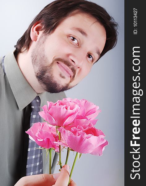 Cute man offering pink roses and smiling