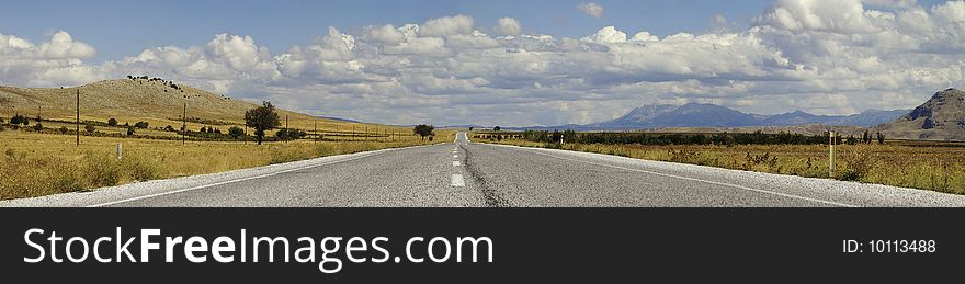 A close to ground panorama of a highway running through mountainous area on a cloudy day. A close to ground panorama of a highway running through mountainous area on a cloudy day.