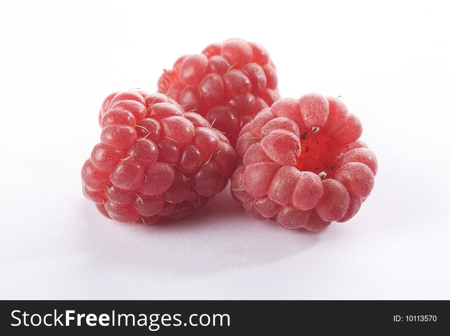 Close up of three raspberries on a white background isolated. Close up of three raspberries on a white background isolated.