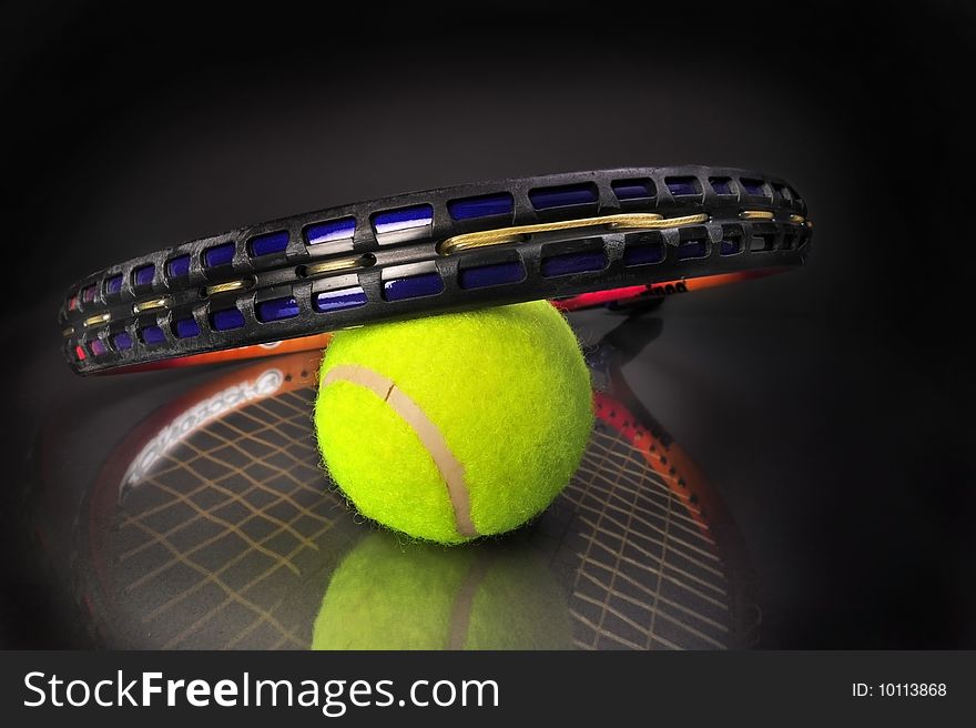 Tennis ball and racket on black background ready for your type.