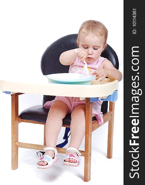 Baby sitting on the black chair isolated