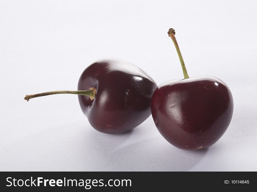 Close up of two cherries on a white background isolated.