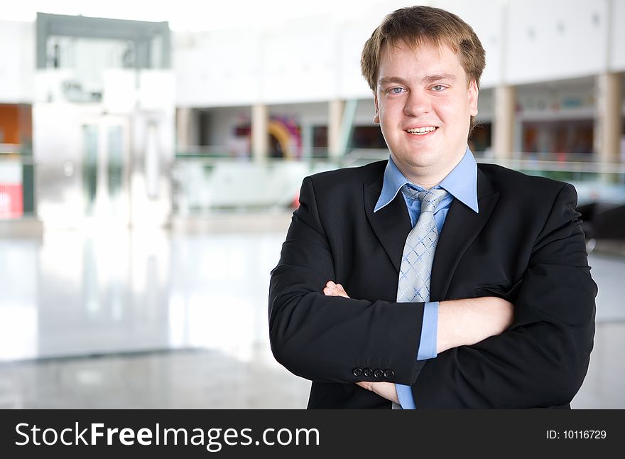 Happy young businessman portrait in business building