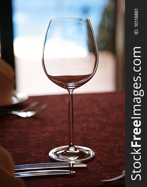 Empty wine glass on a red tablecloth and blue background. Empty wine glass on a red tablecloth and blue background