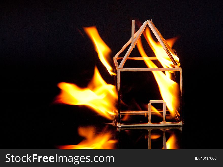 A model house from matches is burning. A model house from matches is burning