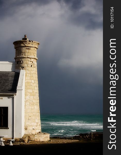 Tower on the shores of the Atlantic Ocean. South Africa. Dark sky (after the storm). Tower on the shores of the Atlantic Ocean. South Africa. Dark sky (after the storm).