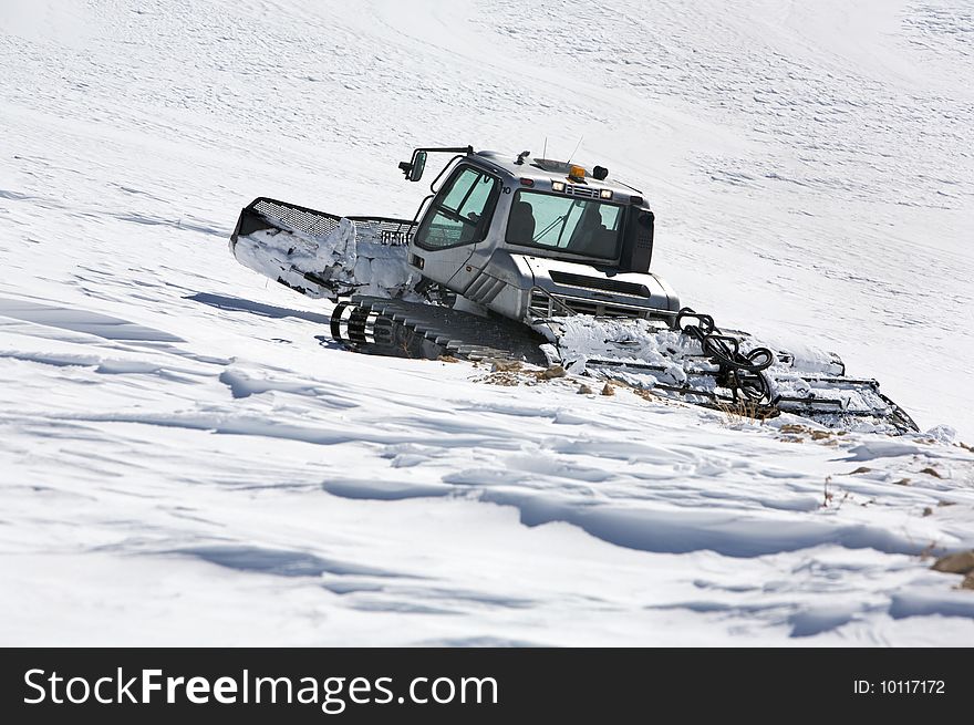 Snowcat goes on slope of mount. Snowcat goes on slope of mount