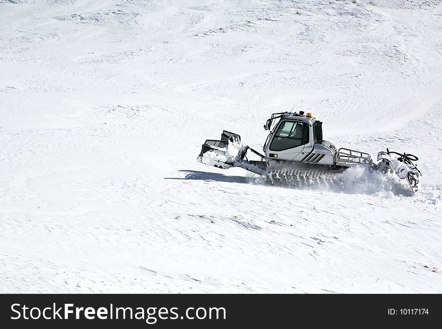 Snowcat goes on slope of mount