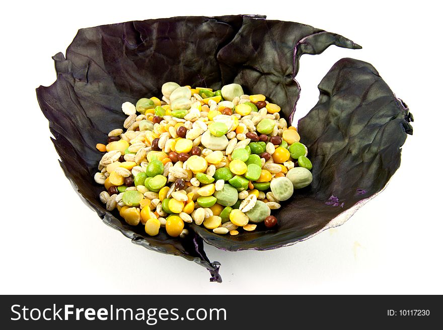 Pile of soup pulses in a red cabbage leaf on a white background. Pile of soup pulses in a red cabbage leaf on a white background