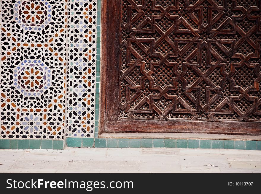 Detail of wood carving en mosaic tiles at Bou Inania Madrassa in Fez, Morocco