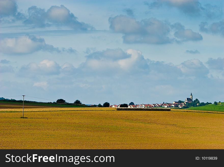 Village on a hill in the countryside against a blue sky