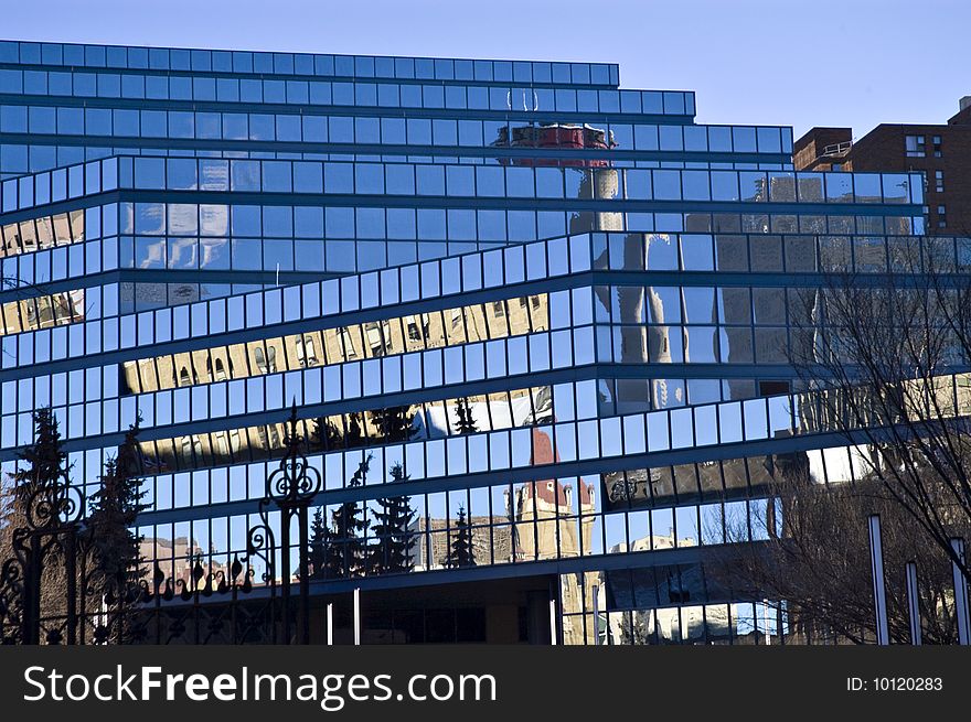 Blue glass building with reflections and many angles