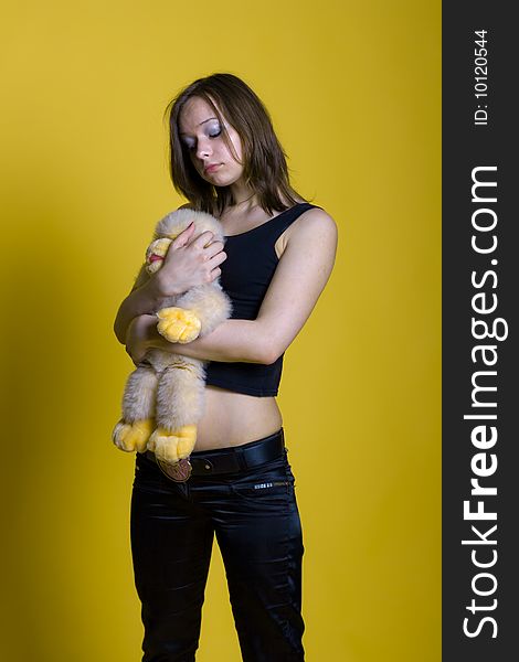 Girl with a toy - yellow monkey on yellow background. Girl with a toy - yellow monkey on yellow background