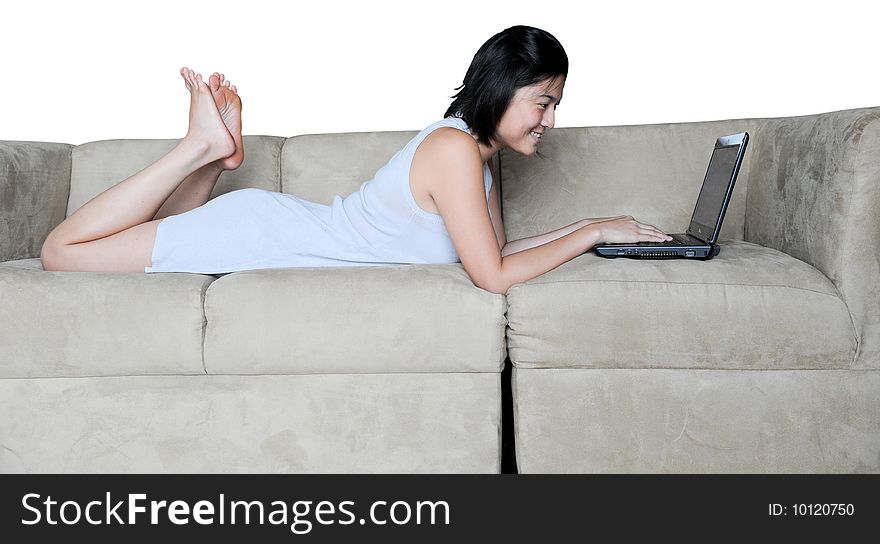 Beautiful Asian girl uses laptop at home on the couch. she is lying down. Beautiful Asian girl uses laptop at home on the couch. she is lying down.