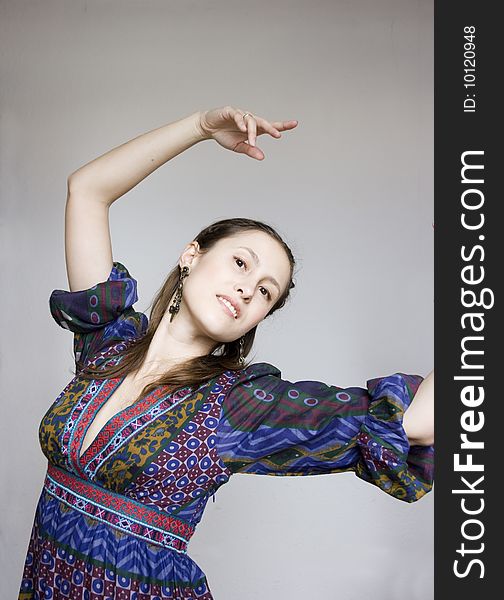 Portrait of young attractive dancing woman in gypsy costume on grey background. Portrait of young attractive dancing woman in gypsy costume on grey background