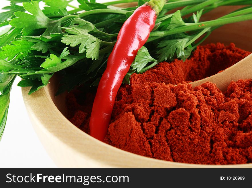 Red paprika with parsley in woodden bowl close-up