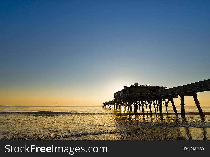 Ocean fishing pier silhouette in colorful sunrise. Ocean fishing pier silhouette in colorful sunrise