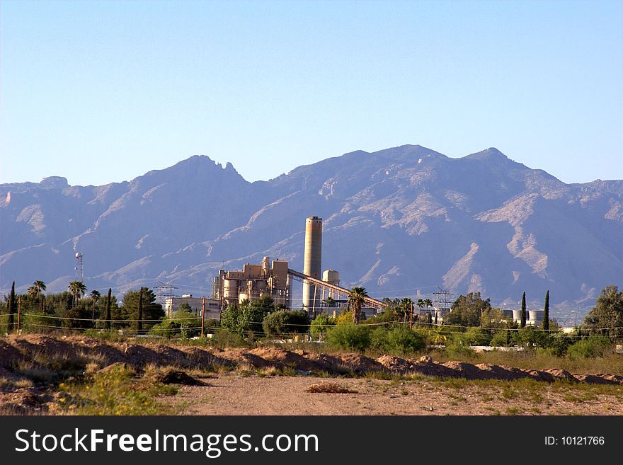 A power plant framed by mountains in the background