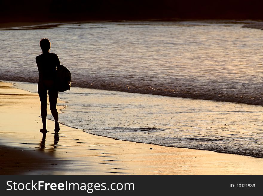 Silhouette of woman walking by the seaside