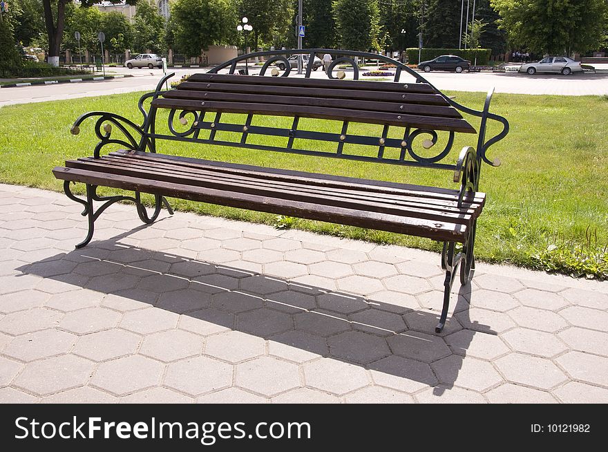 Wooden bench with forged railing in the park. Wooden bench with forged railing in the park