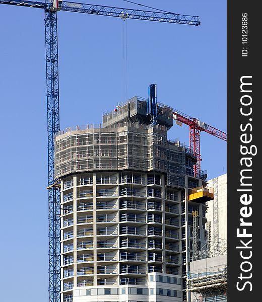 Modern building under construction against clear blue sky. Modern building under construction against clear blue sky