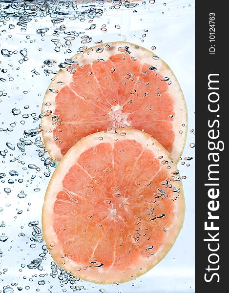 Red grapefruit in water. Creative fruit and bubbles water