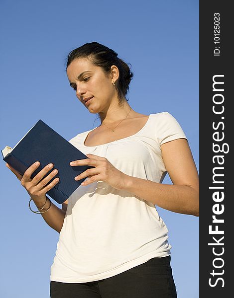 Young beautiful girl reading a book