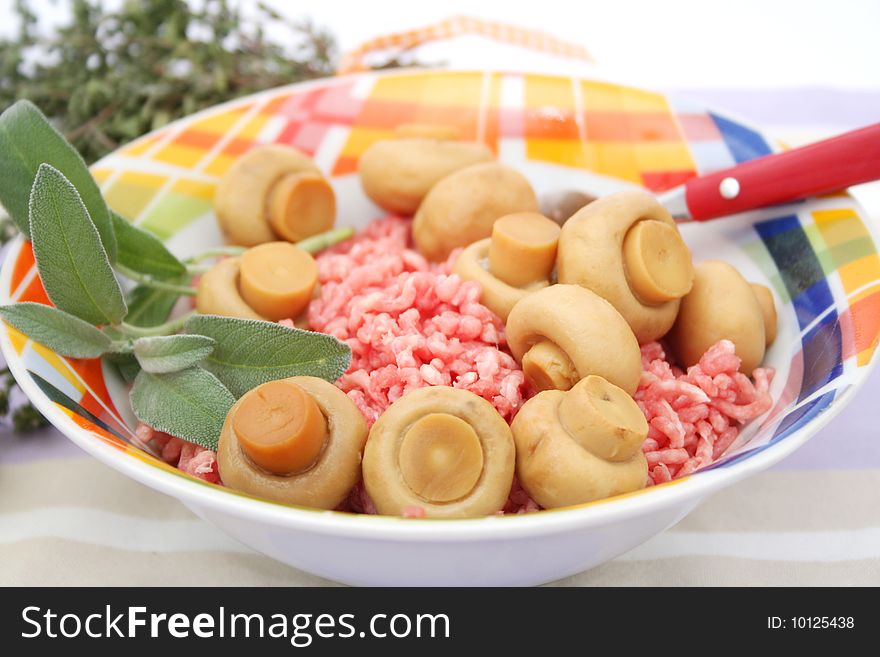 Some fresh pork meat with mushrooms in a bowl. Some fresh pork meat with mushrooms in a bowl