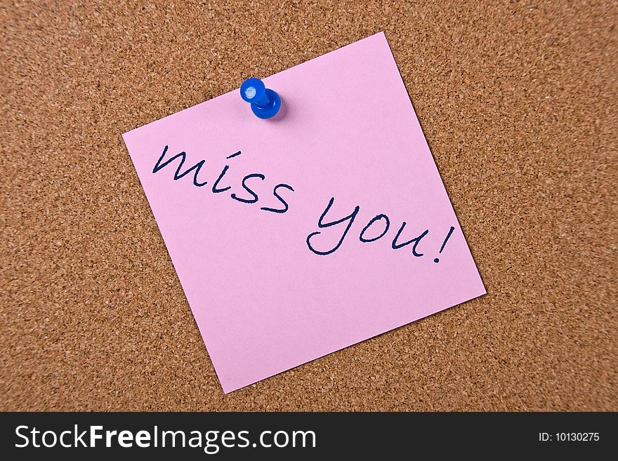 Pink note with blue pin and miss you text