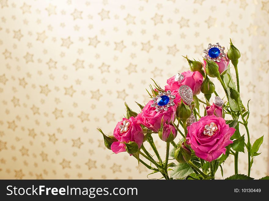Pink roses with jewellery on pattern background