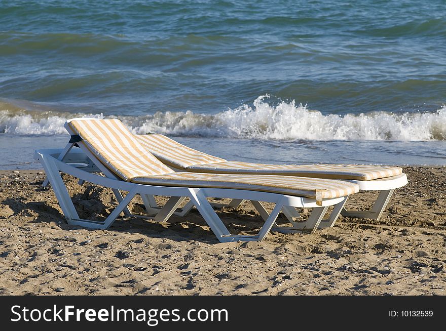 Chaise-lounge on beach at sea