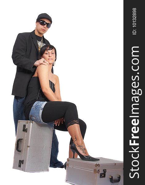 Young stylish couple isolated over white. She is sitting on dj cases. Young stylish couple isolated over white. She is sitting on dj cases.