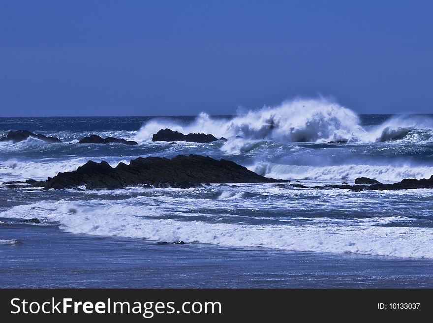 Surf crashing over rocks and onto the beach