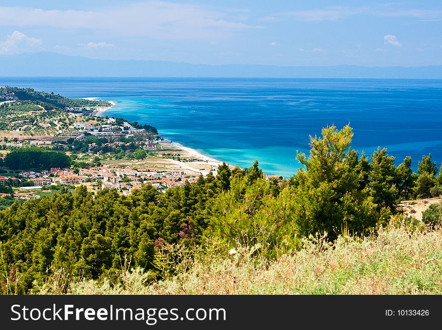 Marine landscape. Greece, Kassandra. Blue sea and sky, small towns with red roofs.
