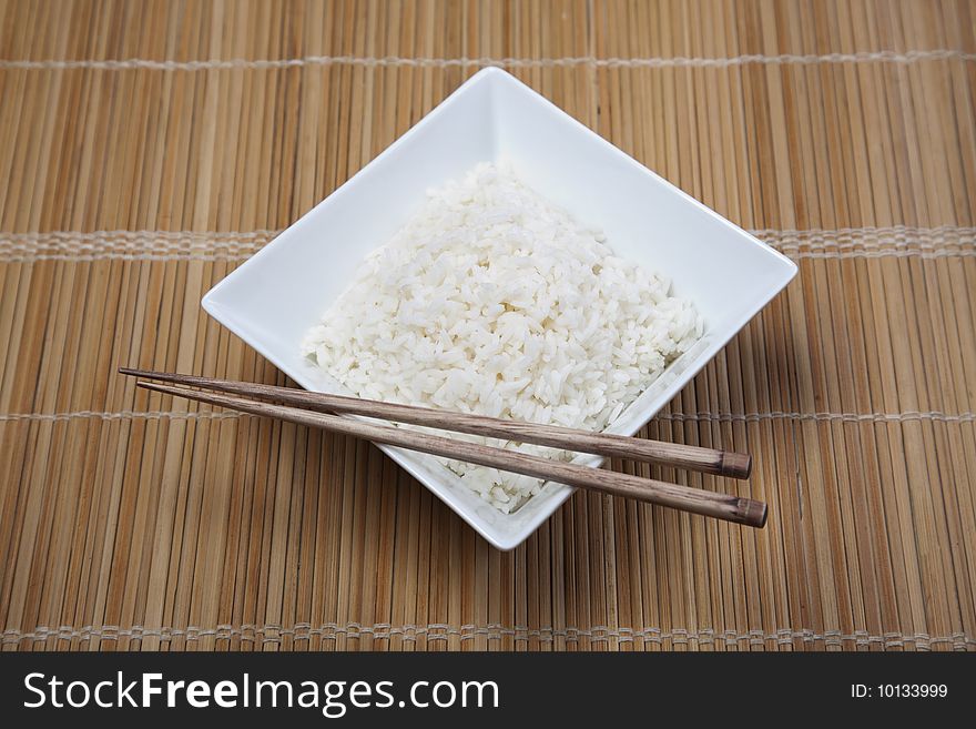 A bowl of perfectly cooked, plain Basmati rice, in an Asian style bowl, with a garnish of Thai Basil. A bowl of perfectly cooked, plain Basmati rice, in an Asian style bowl, with a garnish of Thai Basil