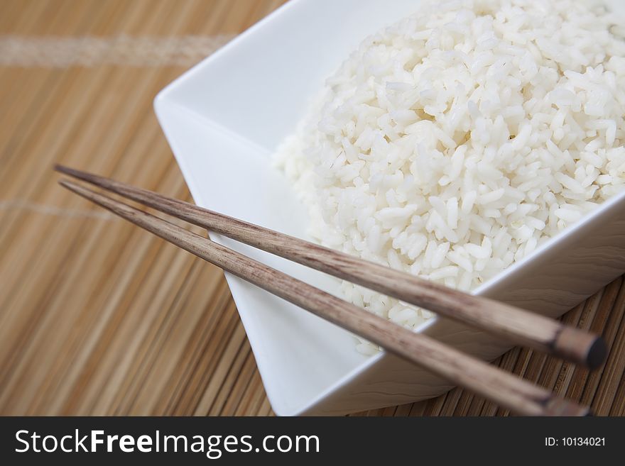 A bowl of perfectly cooked, plain Basmati rice, in an Asian style bowl, with a garnish of Thai Basil. A bowl of perfectly cooked, plain Basmati rice, in an Asian style bowl, with a garnish of Thai Basil