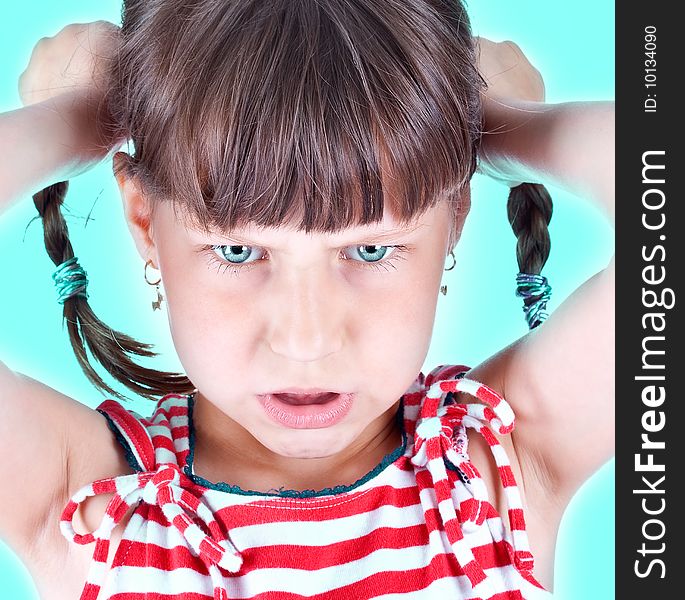 Upset little green eyed girl with pigtails over green background