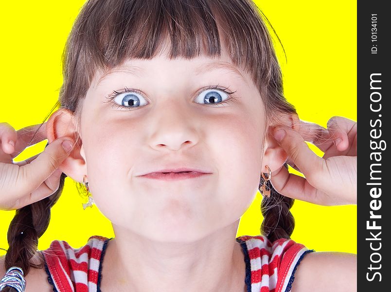 Cute little blue eyed girl making grimace, studio shot