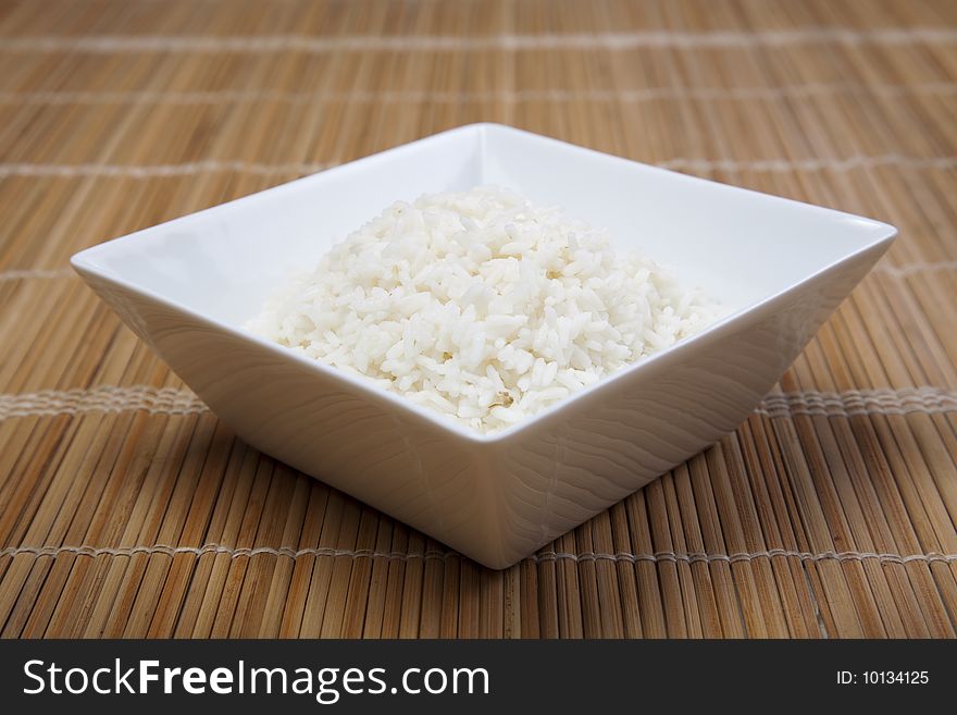 A bowl of perfectly cooked, plain Basmati rice, in an Asian style bowl, with a garnish of Thai Basil. A bowl of perfectly cooked, plain Basmati rice, in an Asian style bowl, with a garnish of Thai Basil