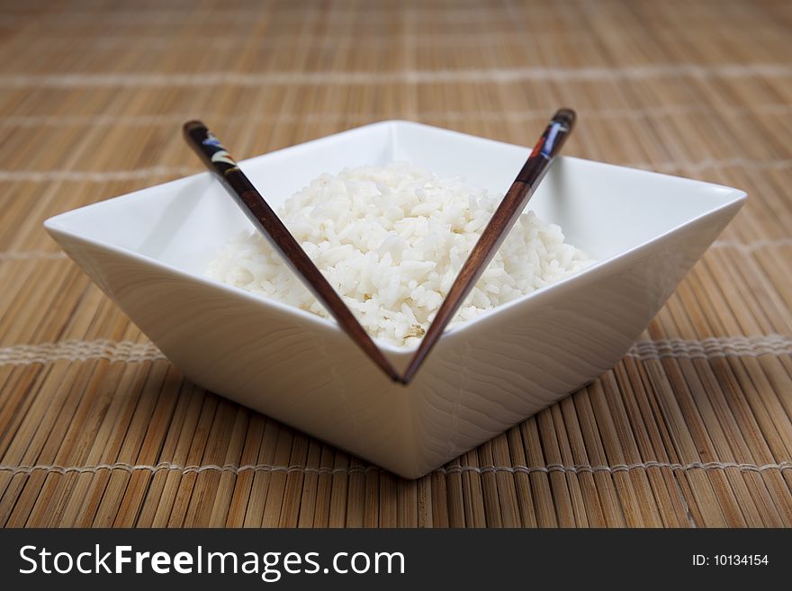 A bowl of perfectly cooked, plain Basmati rice, in an Asian style bowl, with a garnish of Thai Basil. A bowl of perfectly cooked, plain Basmati rice, in an Asian style bowl, with a garnish of Thai Basil