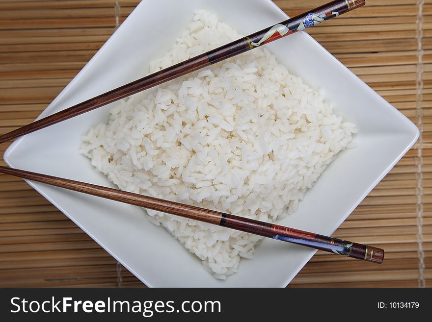 A bowl of perfectly cooked, plain Basmati rice, in an Asian style bowl, with a garnish of Thai Basil. A bowl of perfectly cooked, plain Basmati rice, in an Asian style bowl, with a garnish of Thai Basil