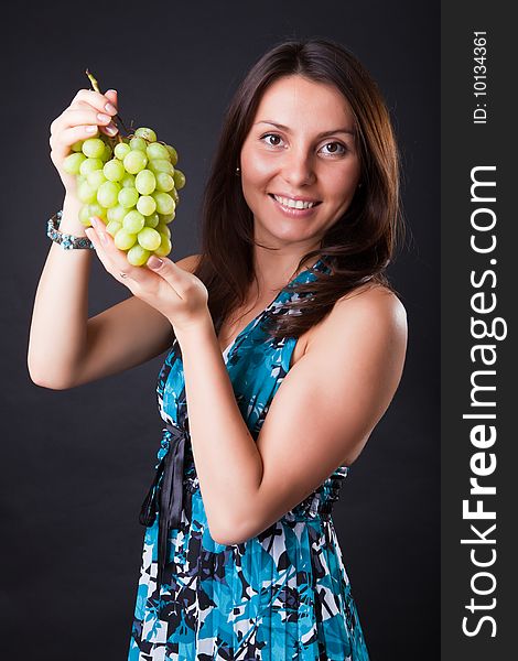 Beautiful girl with grapes cluster